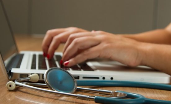 doctor typing on computer