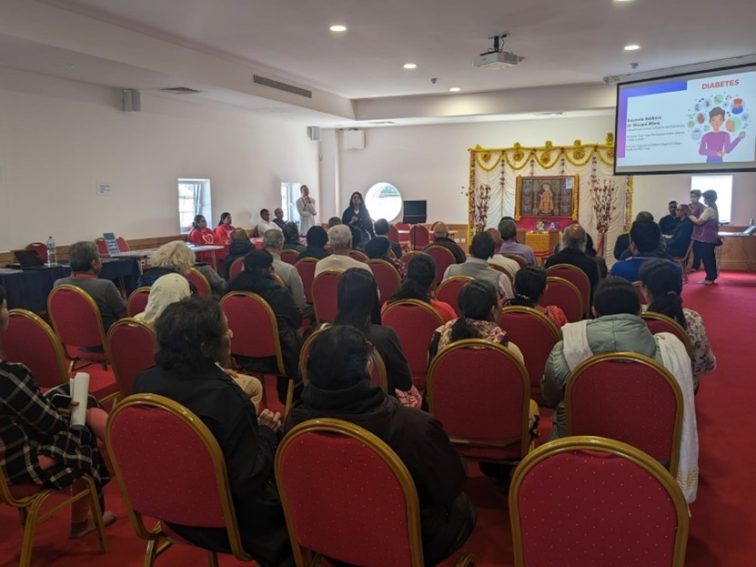 a lecture room with patients listening to an update on diabetes research from a researcher