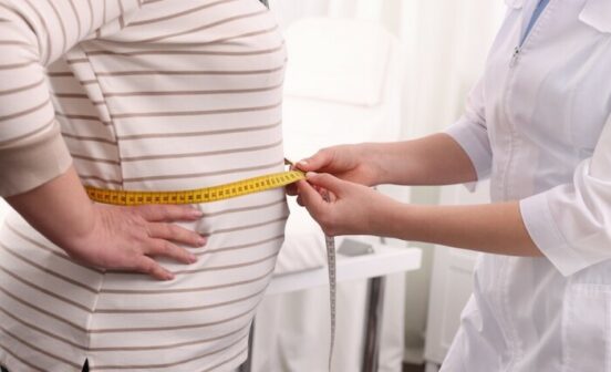 Nutritionist,Measuring,Overweight,Woman's,Waist,With,Tape,In,Clinic,,Closeup